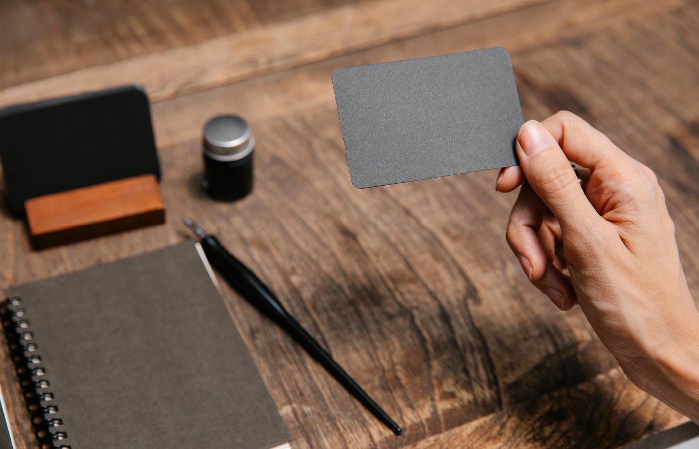 A business card being held over a desk